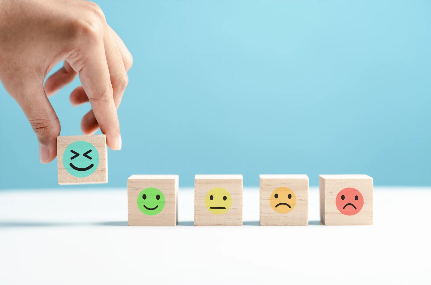 A hand choosing from colourful emotion blocks