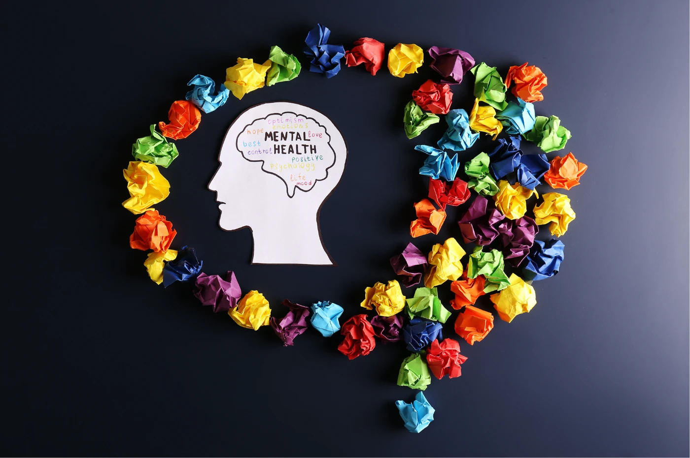 A paper head surrounded by colourful paper shapes