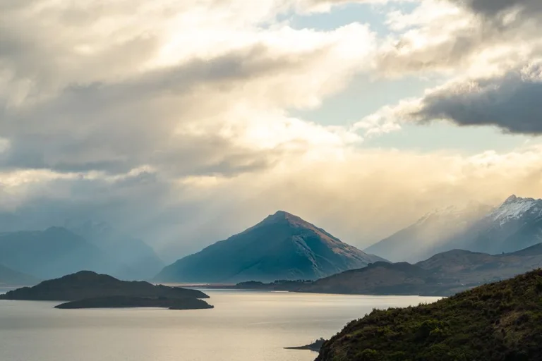 Morning sunlight over mountains and calm water