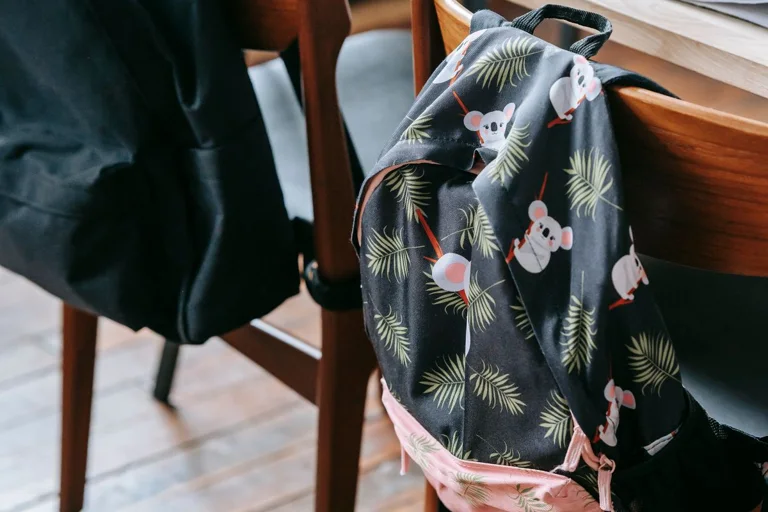 A school backpack hanging beside a classroom desk